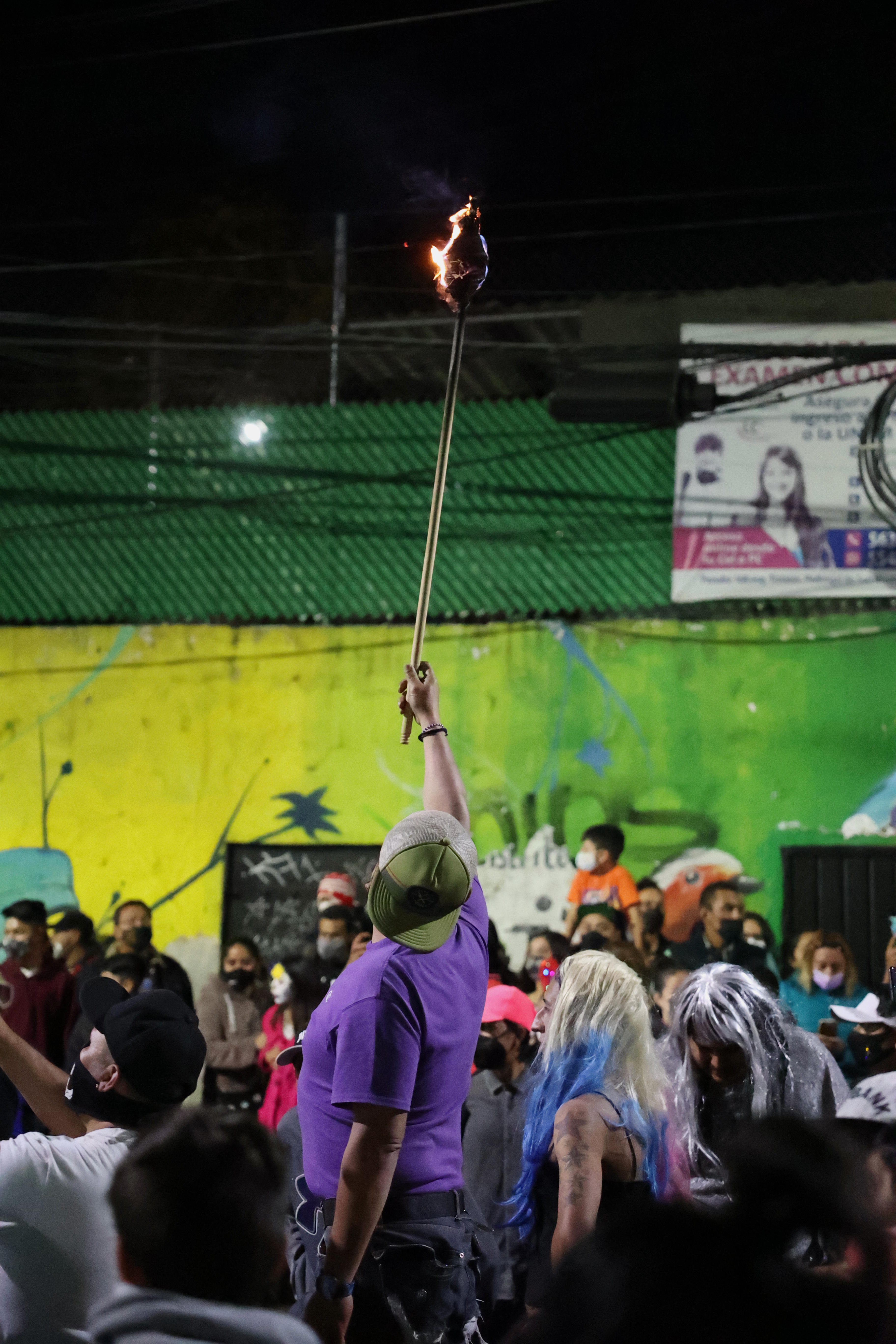 Leading the way for a Día de Muertos parade, a man holds up a torch in Mexico City's Magdalena Contreras delegation on Nov. 2, 2021.